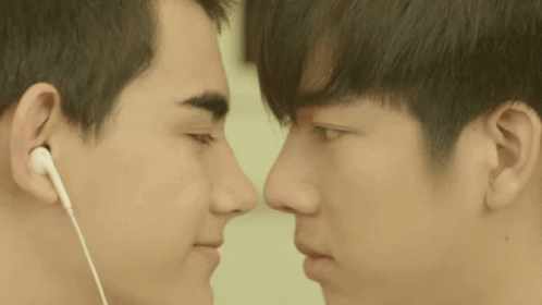 Two Young Men Looking At Each Other Wearing Earbuds GIF