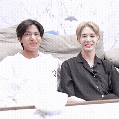 Two Young Men On Couch, One In White Heart Shirt GIF