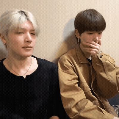 Two Young Men, One Covering Mouth GIF
