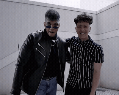 Two Young Men Posing One In Black Jacket GIF