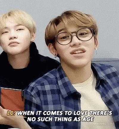Two Young Men Sitting Next To Each Other One With Glasses And Plaid Shirt GIF