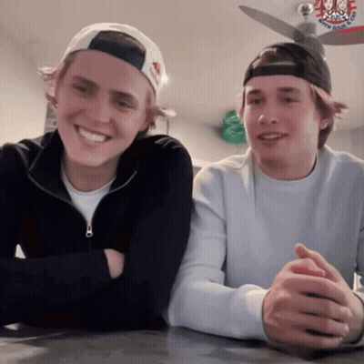 Two Young Men Sitting With Army Navy Air Force Hat GIF
