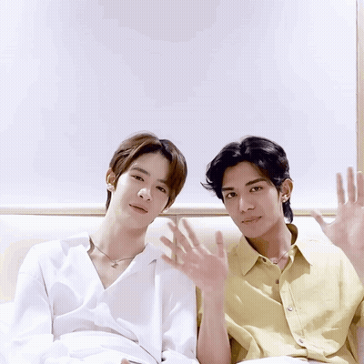 Two Young Men Sitting With Hands Up GIF