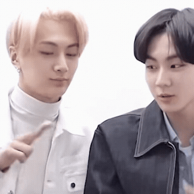 Two Young Men Standing And Looking At Each Other GIF