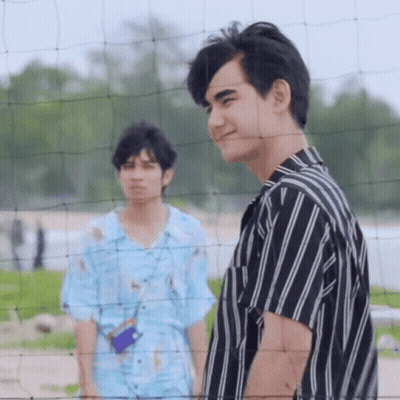 Two Young Men Standing By Volleyball Net On Beach GIF