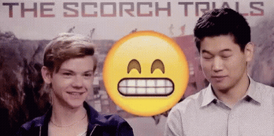 Two Young Men Standing In Front Of The Scorch Trials Poster GIF