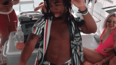 Two Young Men Standing In Room One Wearing NM Shirt GIF