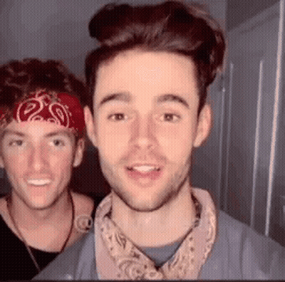 Two Young Men Standing Next To Each Other One Wearing Bandana GIF