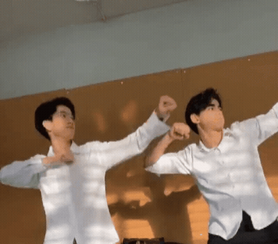 Two Young Men Standing Next To Each Other GIF