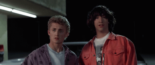 Two Young Men Standing Next To Each Other With Their Hands Up In The Air GIF