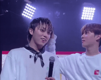 Two Young Men Standing On Stage With Microphone GIF
