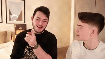 Two Young Men Talking In A Room GIF