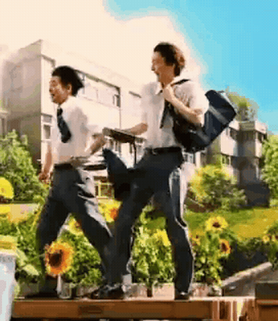 Two Young Men Walking Across Wooden Bridge GIF