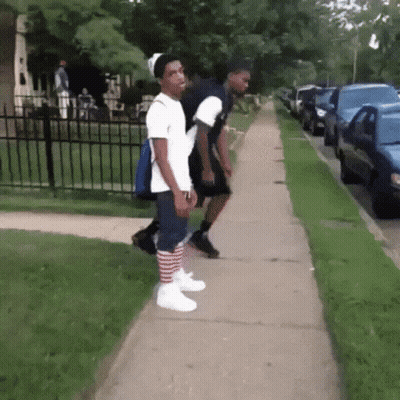 Two Young Men Walking, One In Striped Socks GIF