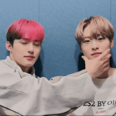 Two Young Men With Pink Hair Sitting Next To Each Other GIF