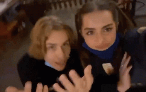 Two Young Women Are Posing For A Picture Together . GIF