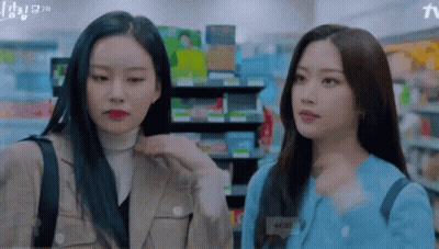 Two Young Women Looking At Each Other In Store GIF