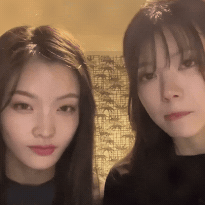 Two Young Women Standing Next To Each Other GIF