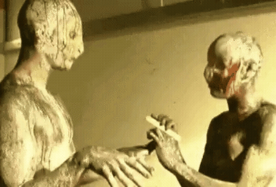Two Zombies Are Standing Next To Each Other In Front Of A Mirror . One Of The Zombies Is Holding A Knife . GIF