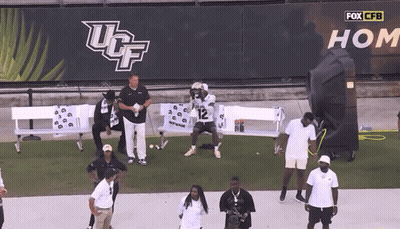 UCF Football Player Number 12 Kneeling On Field GIF