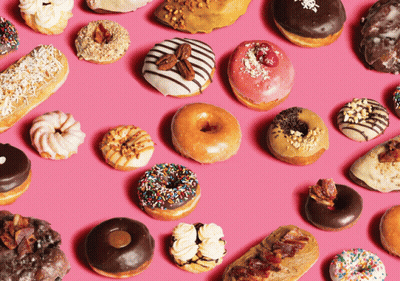 Variety Of Donuts Lined Up On Pink Surface GIF