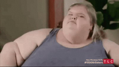 Very Fat Woman Sitting On Couch Looking At Camera GIF