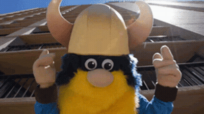 Viking Mascot Thumbs Up In Front Of Building GIF