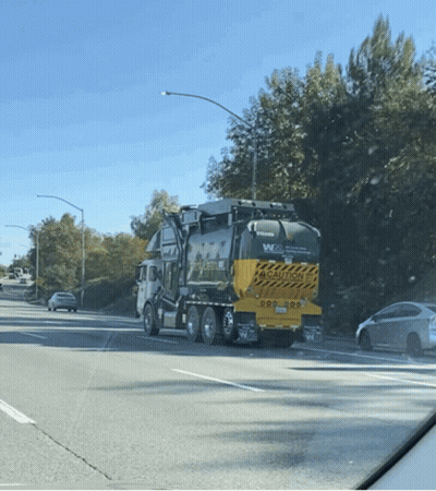 Volvo Garbage Truck Driving Down Street GIF