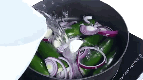 Water Is Being Poured Into A Pot Of Green Peppers Onions And Garlic Sticker