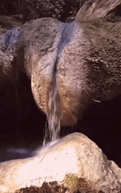 Waterfall Surrounded By Rocks And Trees GIF