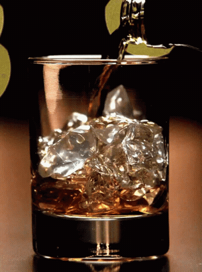 Whiskey Bottle Poured Into Ice Glass GIF