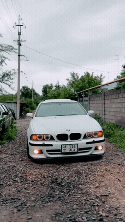 White BMW Parked On Gravel Road License Plate DZ-215 GIF