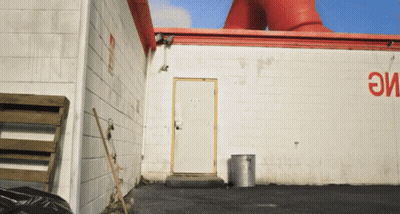 White Building With Red Sign Saying Eme GIF