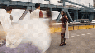 White-Caped Man And Red-Dressed Woman On Highway GIF