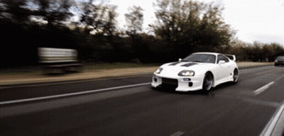 White Car Driving Down Road With Trees GIF