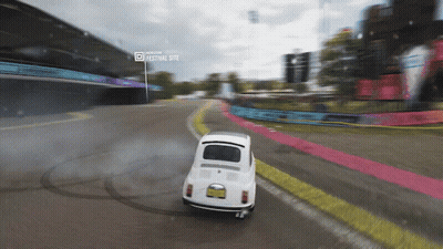 White Car Driving On Road Near Festival Site GIF