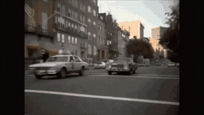 White Car With Number 1 Driving Down Street