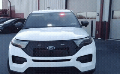 White Ford Police Car Parked In Front Of Garage With Red Light GIF