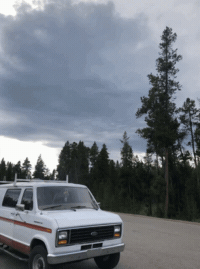 White Ford Van Parked In Lot With Trees GIF