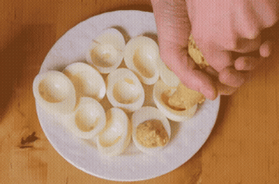 White Plate With Hard Boiled Eggs Stuffed With Mustard GIF