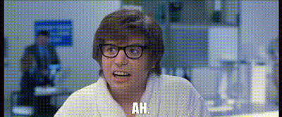 White Robot Laying On Table With Pillow GIF