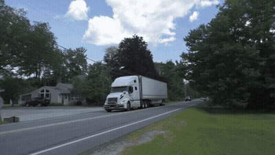 White Semi Truck Driving Down Road With Trees GIF