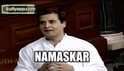 White Shirt Man With Namaskar By Wooden Wall GIF
