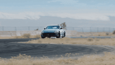 White Sports Car Driving Down Road GIF