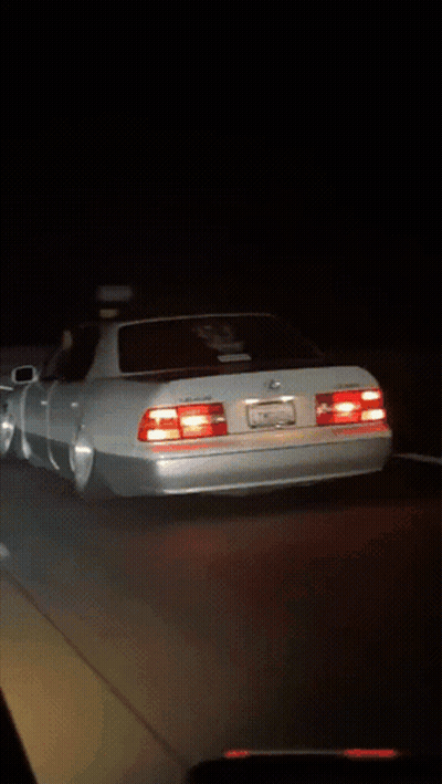 White Sports Car Parked In Dark Parking Lot At Night GIF