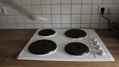 White Stove Top With Four Black Burners And White Knob GIF