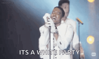 White Suited Singer At Mic With Man Behind GIF