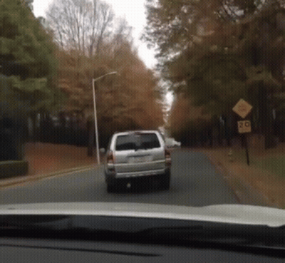 White SUV Driving Down Road With 20 Sign GIF
