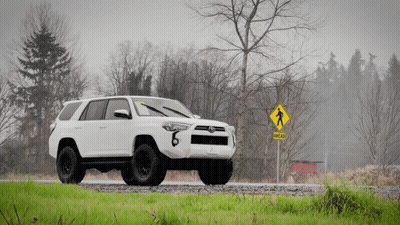 White SUV Parked Near Pedestrian Crossing Sign Saying Head GIF