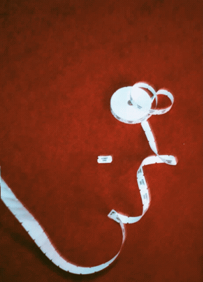 White Tape Measure Labeled A On Red Surface GIF